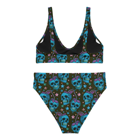 Two-piece high-waisted bikini set featuring an all-over print of blue skulls with purple bows and multicolored stars on a dark background. Includes a deep V-neck bikini top with wide straps and matching high-rise bottoms. Made from soft, stretchy fabric with a smooth black inner lining. The design combines bold, edgy graphics with a flattering retro-inspired silhouette.